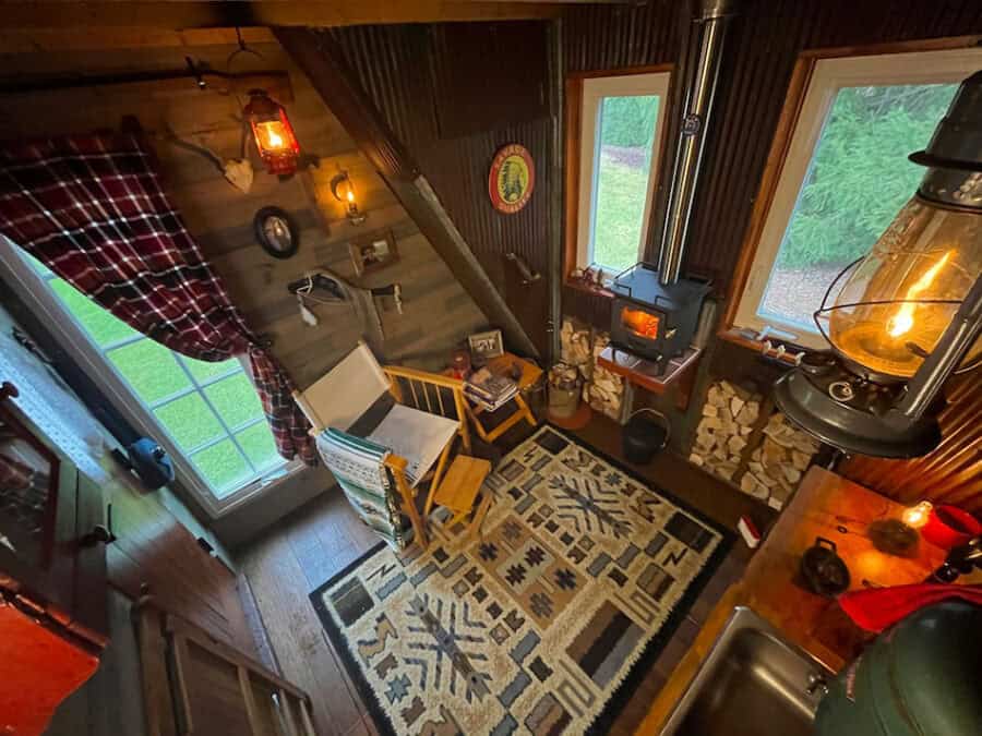 Rustic tiny cabin interior featuring a wood stove, cozy seating, and natural light. Perfect for off-.