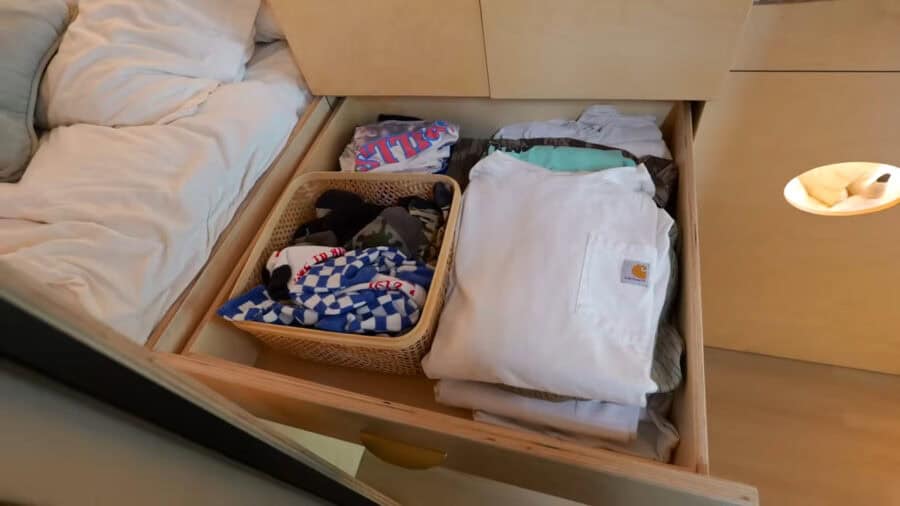 Organized drawer with clothes and accessories in a tiny house.