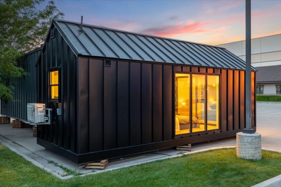 Compact black tiny house with large glass doors and modern design.