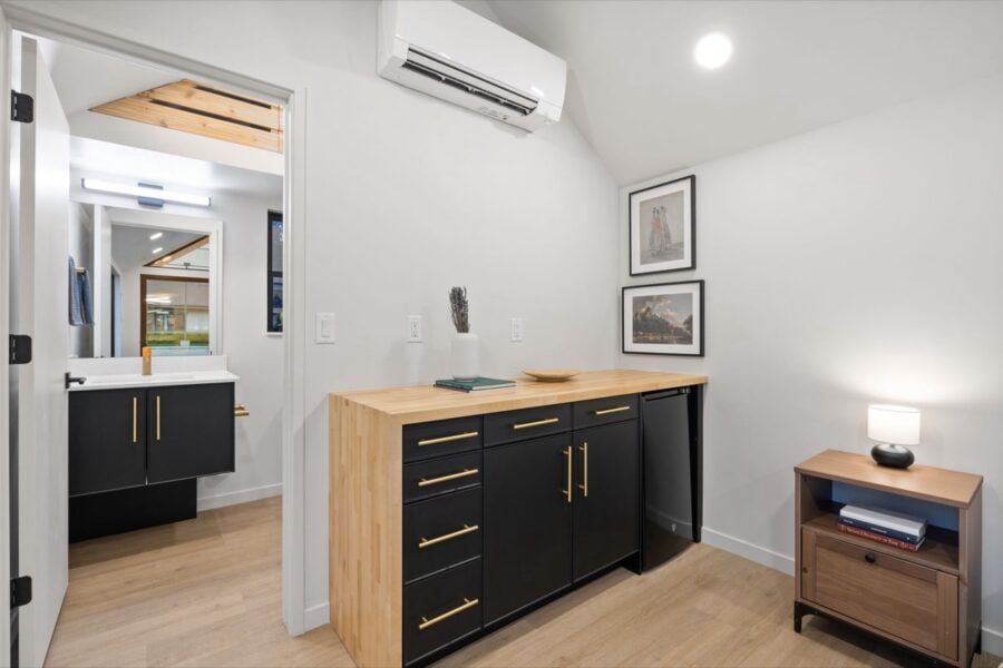 Compact tiny house interior with modern black cabinetry and wooden accents.