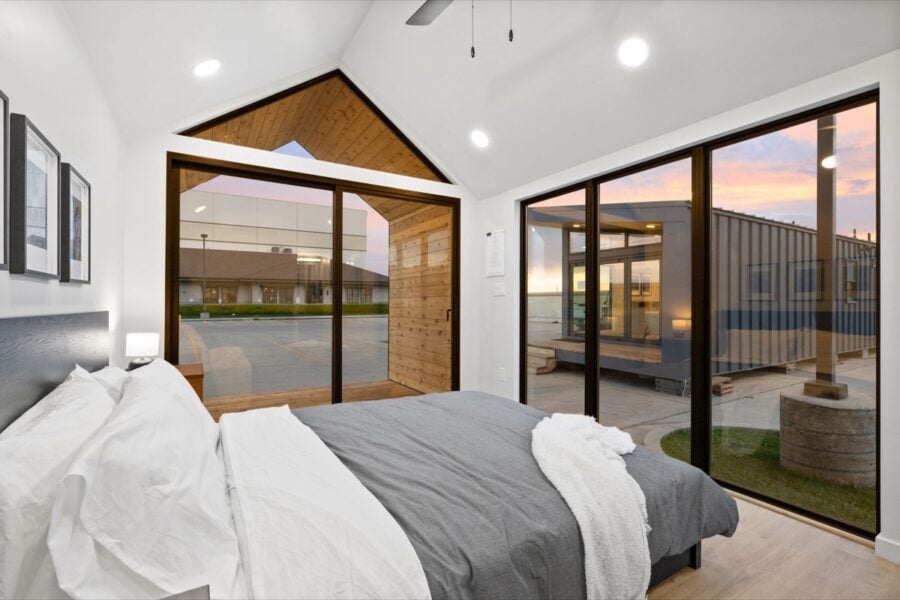 Modern tiny house bedroom with large windows and natural light.