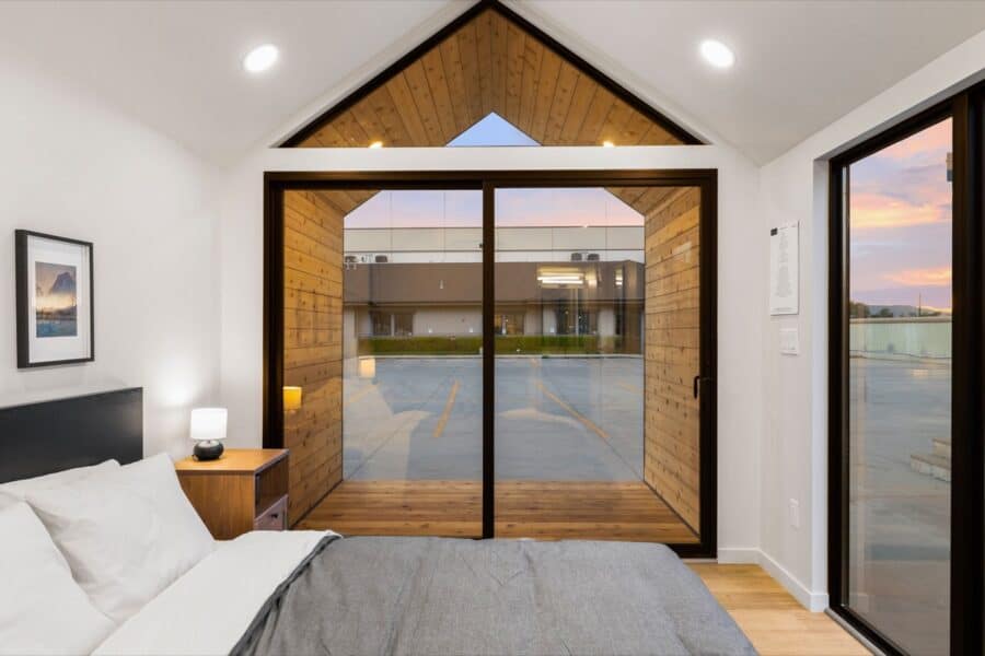 Cozy interior of Mysa 200 Park Model Tiny House with large windows and modern design.