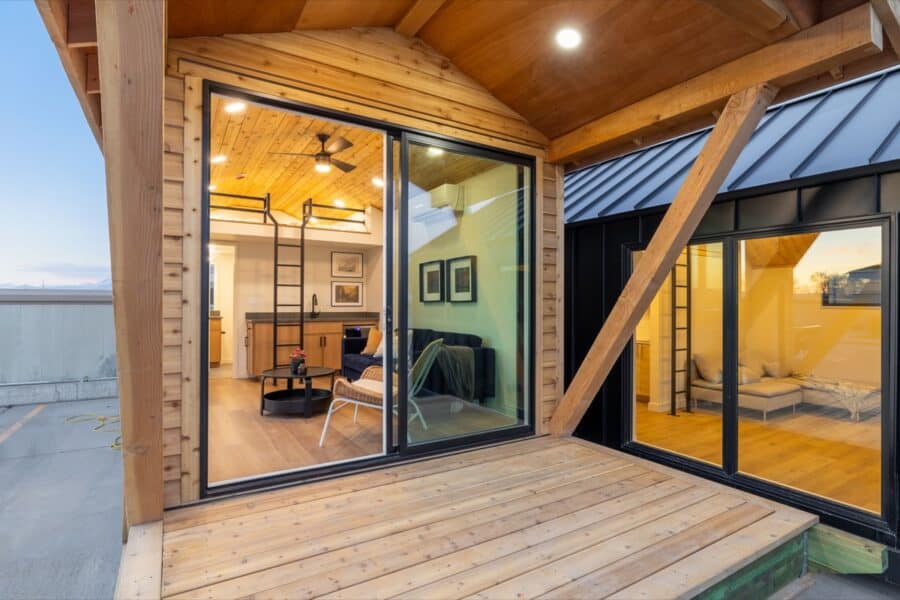 Modern tiny house interior with large glass doors and cozy living area.