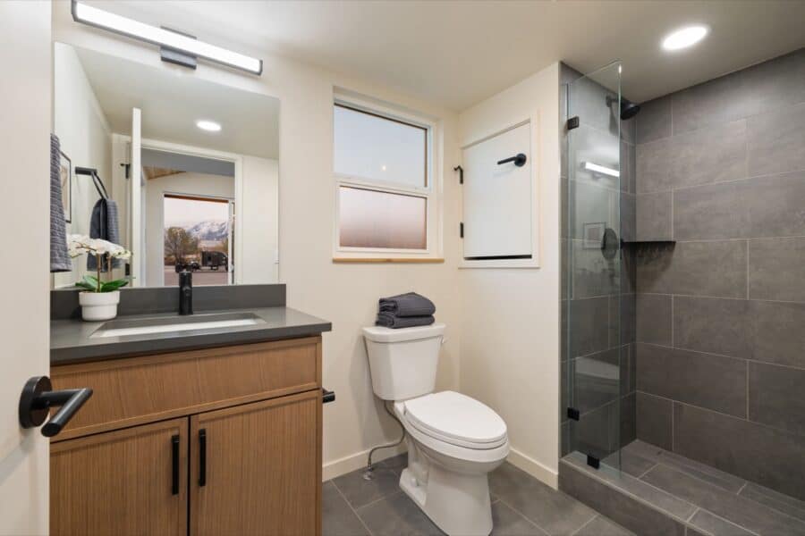 Compact bathroom in a tiny house with modern fixtures and a walk-in shower.