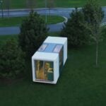 Modern tiny house on green lawn with trees, compact and portable design.