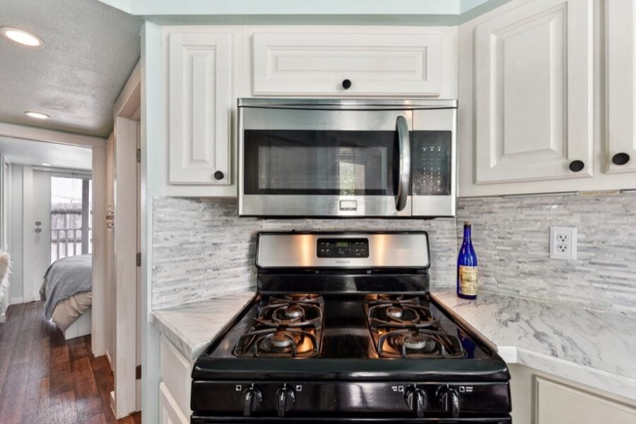 Compact tiny house kitchen with modern appliances near Austin.