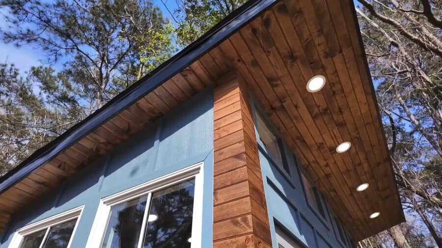 Modern tiny house with backyard gym and wooden accents, perfect for small space living.