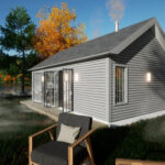 Small one-bedroom cottage with gray siding and large windows, perfect for tiny house living.