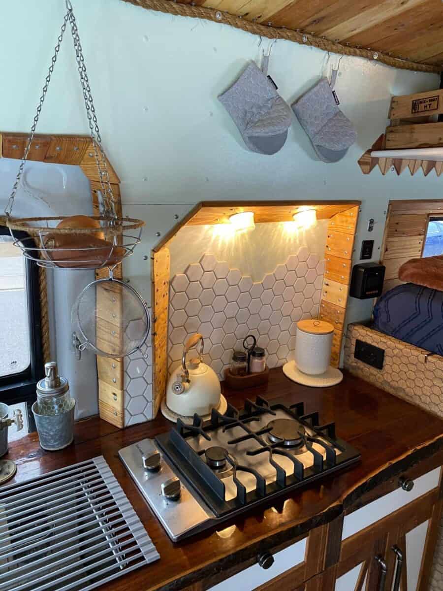 Compact tiny house kitchen with warm lighting and functional design.
