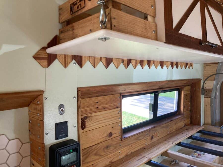 Cozy farmhouse van interior with wooden accents and a small window for natural light.