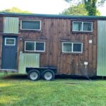 Charming tiny house with a mix of wood and metal exterior, perfect for small space living and outdoo.