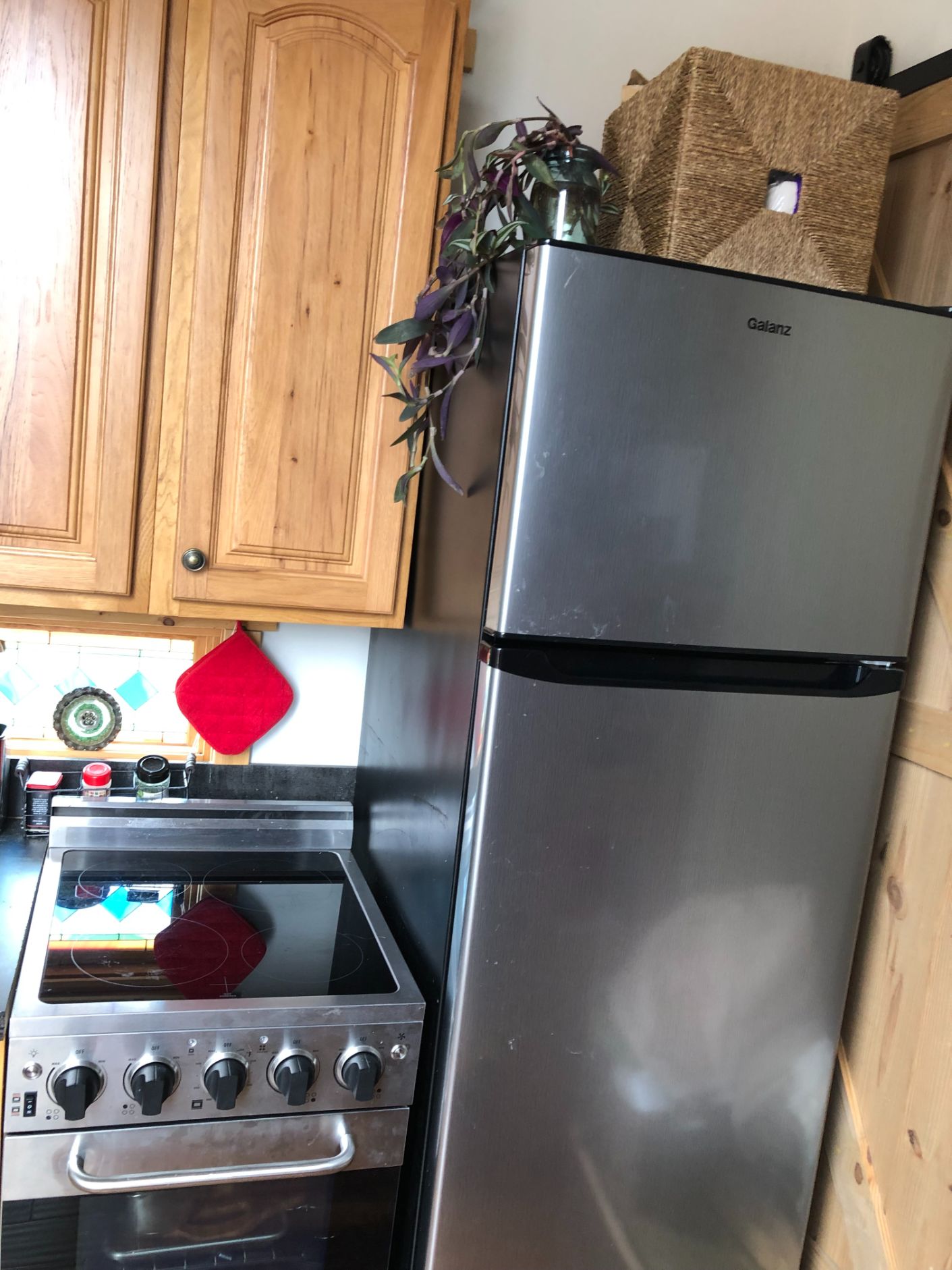Kitchen appliances including a four-burner range and full-sized refrigerator in the Kangaroo tiny house
