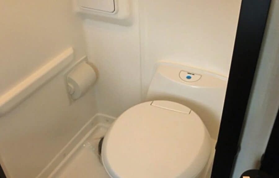 Compact bathroom in tiny house with space-saving toilet and minimalistic fixtures.