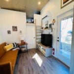 Bright tiny house interior with a comfortable sofa and modern decor.