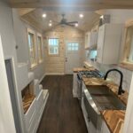 Small modern kitchen in a tiny house with wood accents and natural light.