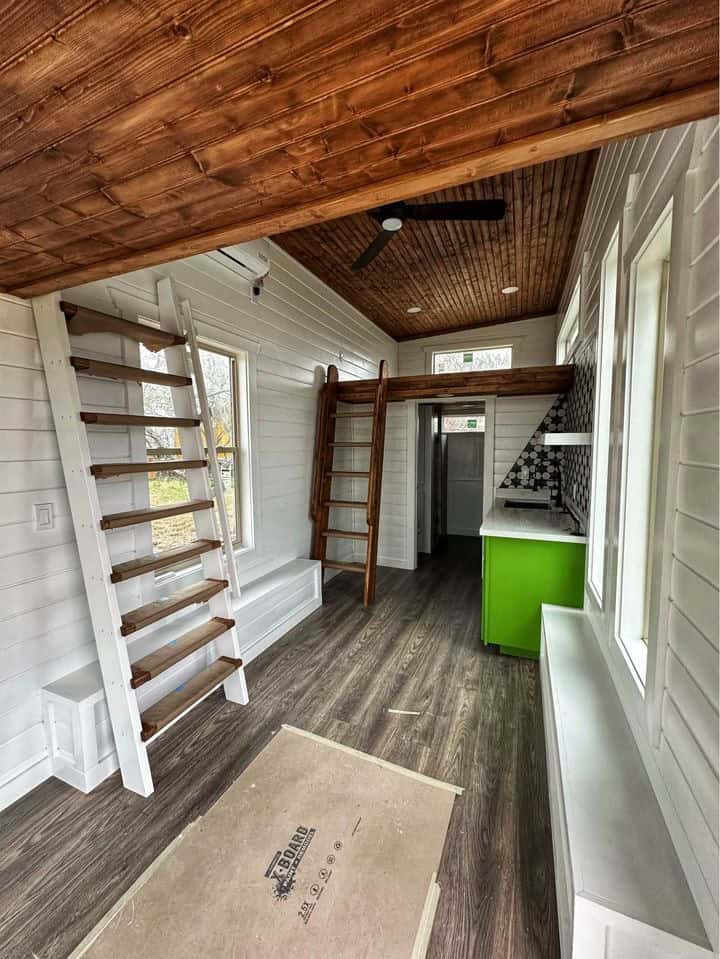 Bright tiny house interior featuring a double loft and modern kitchen. Perfect small space living wi.