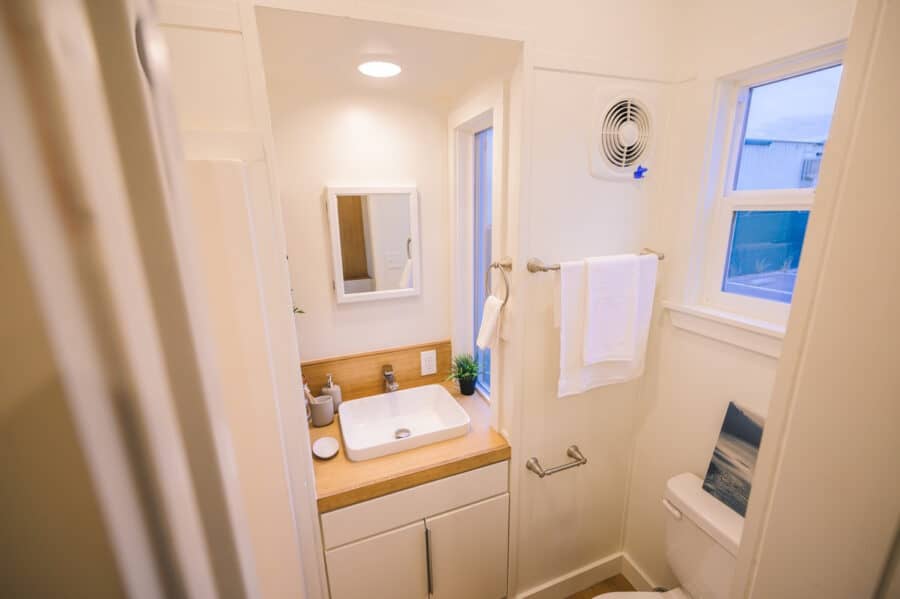 Compact tiny house bathroom with modern fixtures and natural light.