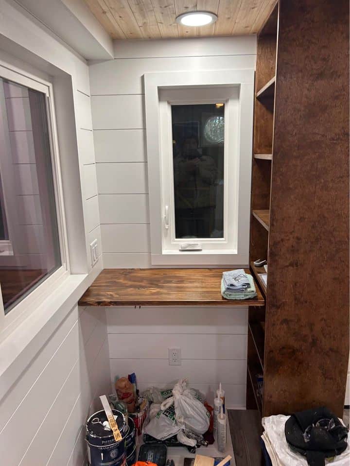 Interior of a tiny house with a small wooden desk and window view.