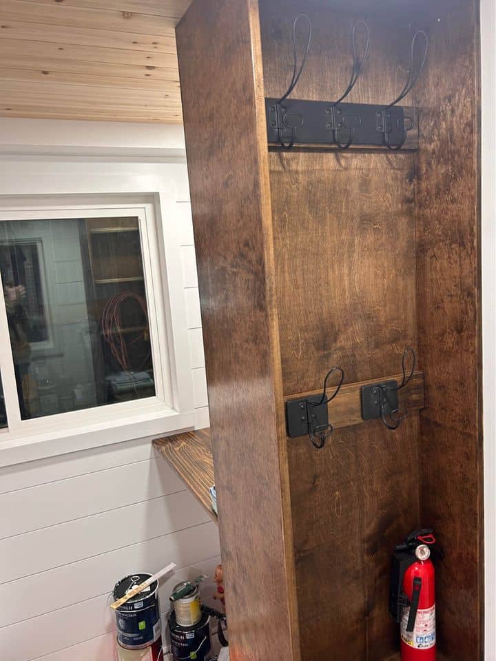 Entryway hooks inside a tiny house for hanging coats and keys.