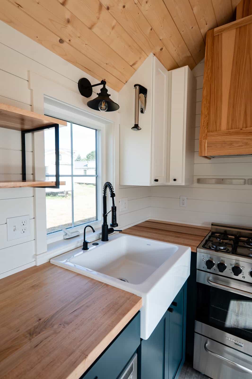 Farmhouse apron sink with black faucet and butcher-block counters