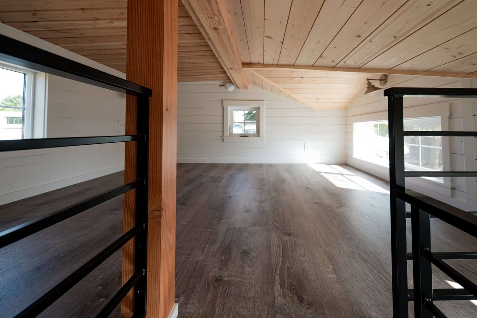 Large upstairs loft with plank flooring, pine ceiling and windows on both ends
