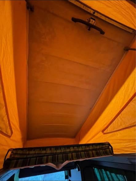 Inside the raised pop-top, with new orange canvas and the upper bunk board