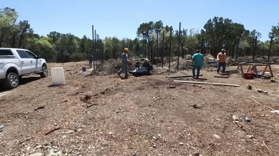 Crew setting fence posts for a large new wolf enclosure at Alveus Sanctuary in Texas