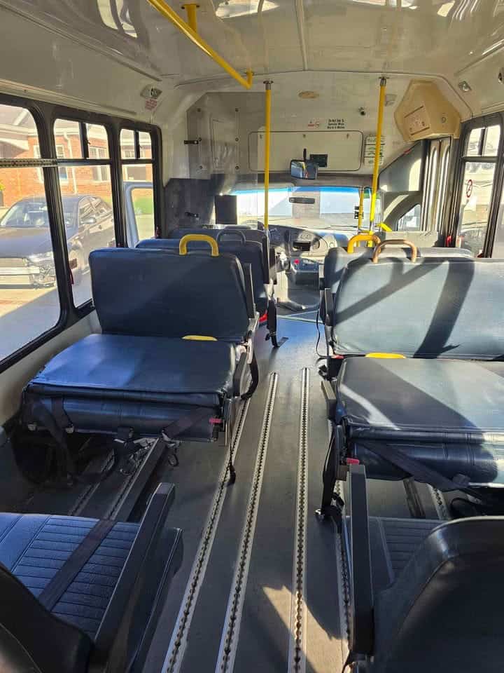 Rows of bus seats and the wheelchair lift area at the back