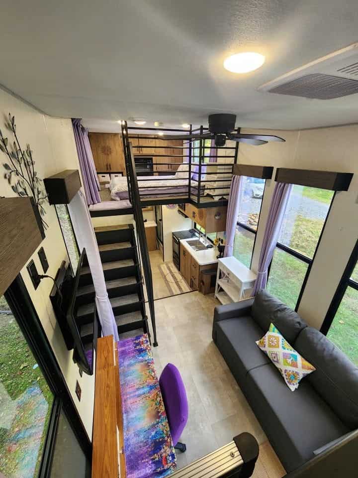 Looking down the full length of the interior from the loft, with the kitchen, sofa, and second loft
