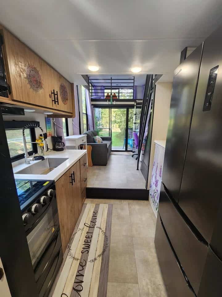 Galley with the range on one side and a tall black refrigerator on the other