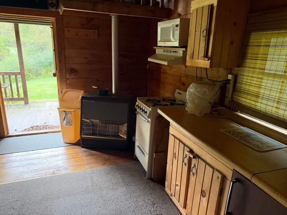 Kitchen corner with a heater beside the gas stove and the open door to the porch
