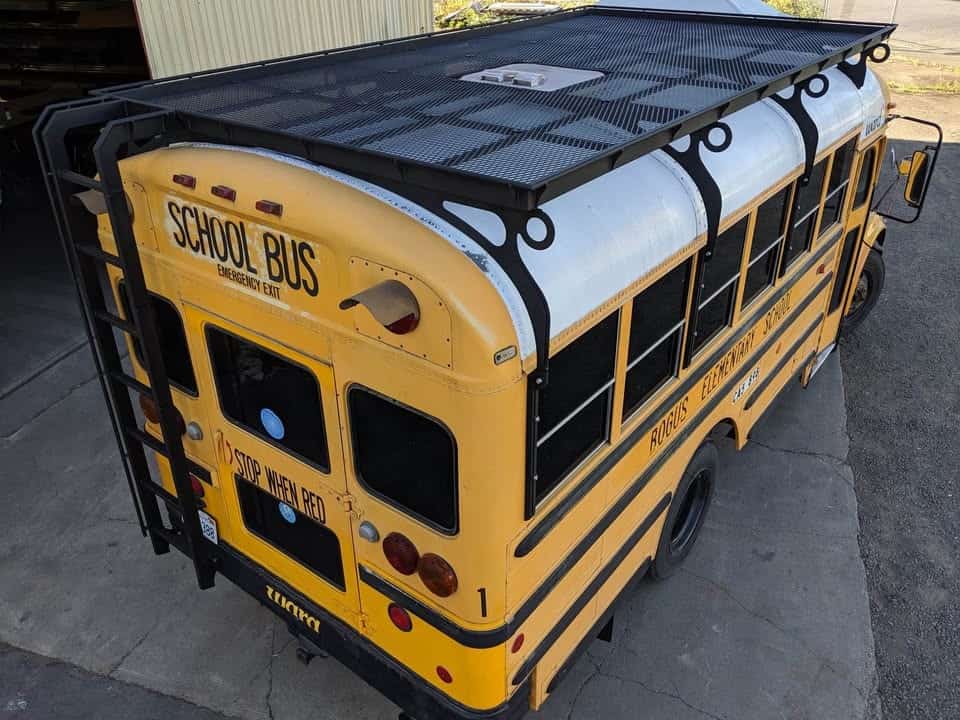 The same shortbus in its original yellow school bus paint with the new black roof rack installed