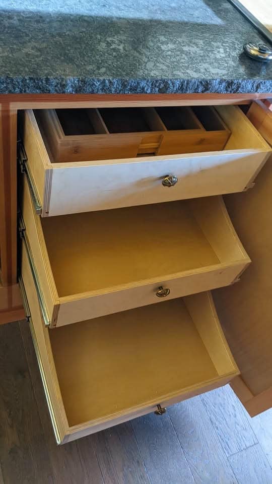 Open wood drawers with a cutlery tray under the counter