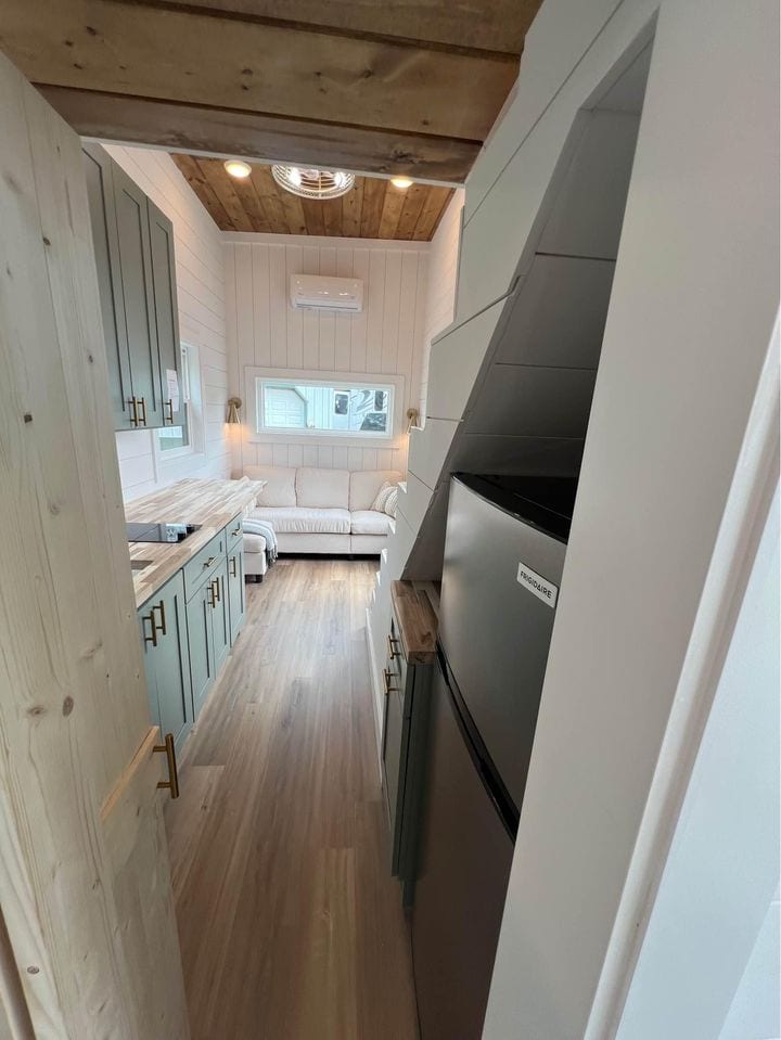 Cozy tiny house kitchen with modern farmhouse style and compact appliances.