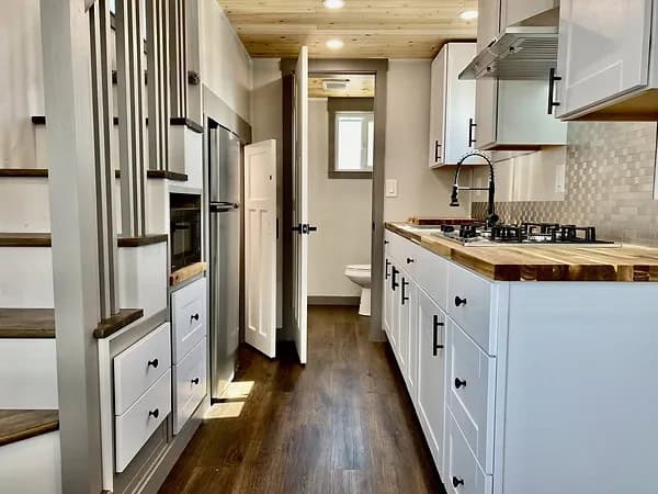 Compact tiny house kitchen with modern appliances and smart storage solutions.
