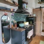 Charming tiny house kitchen with modern appliances and rustic decor in Ontario, Canada.