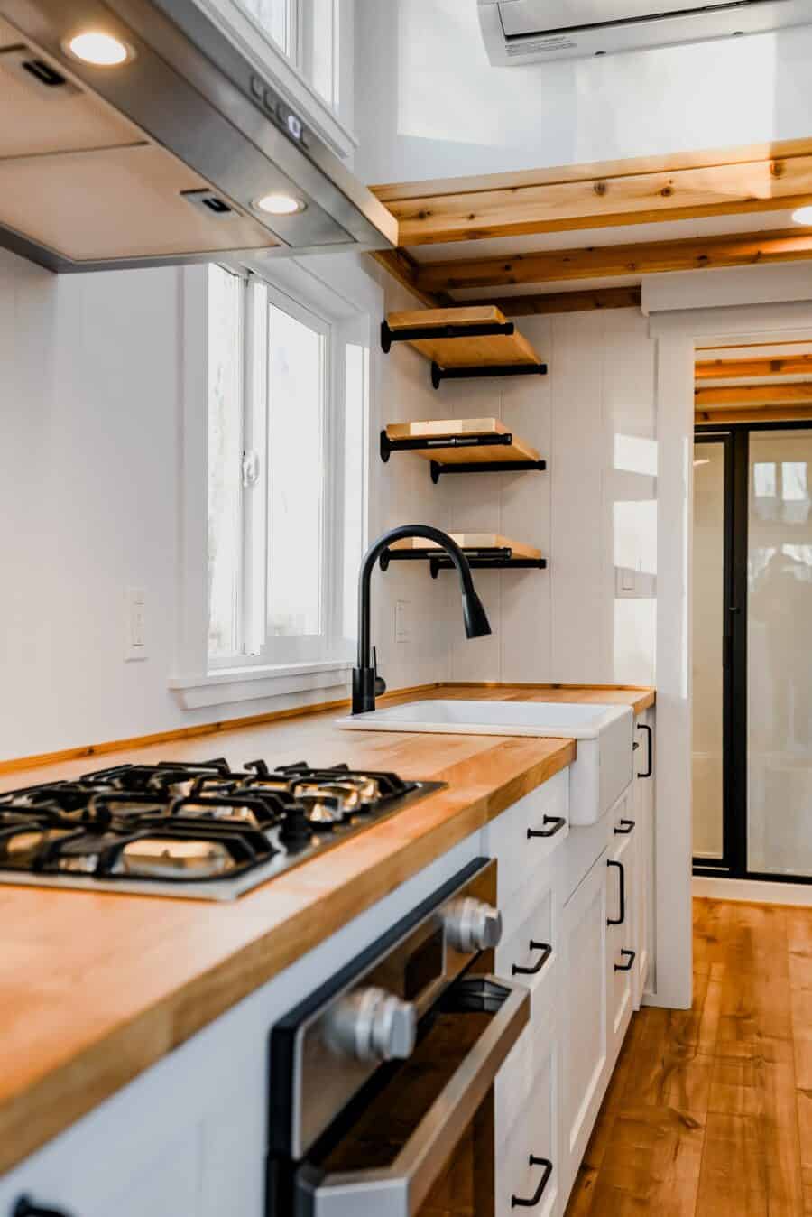 Compact tiny house kitchen with wooden accents and efficient layout.