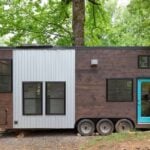 Compact tiny house on wheels with modern design and dual lofts for efficient small space living.