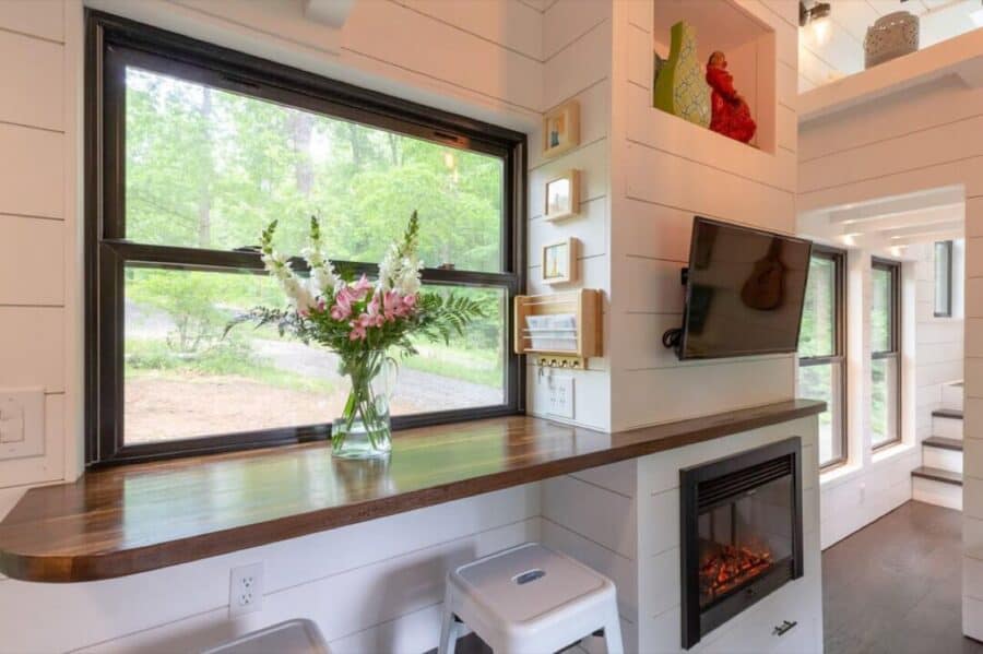 Living area with large window, fireplace, and decorative shelves