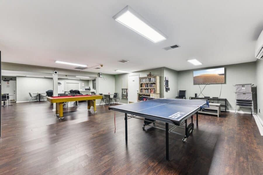 Interior of a recreational room in a tiny house with ping pong and pool tables.