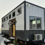 Compact tiny house with a loft bedroom and modern exterior design.