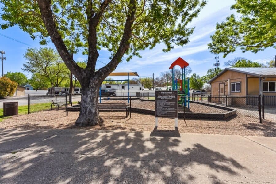 Playground area at Lone Star RV Resort near Austin with tiny houses in the background.