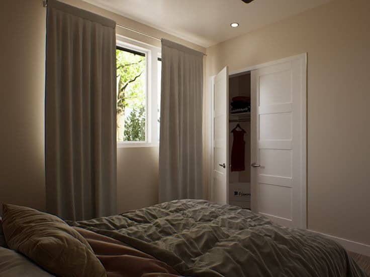 Cozy tiny house bedroom with large window, curtains, and closet space for small space living.