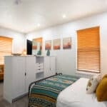 Compact tiny house bedroom with modern decor and natural light.