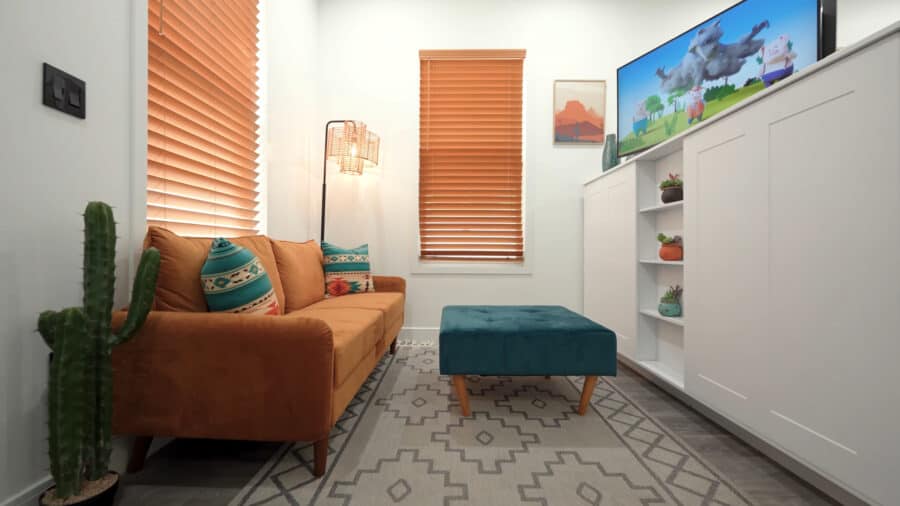 Cozy tiny house living room with sofa, TV, and decor, showcasing small space comfort.