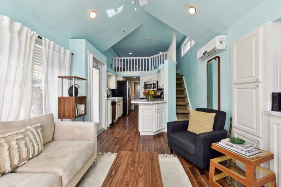 Cozy tiny house interior with bright blue walls, compact kitchen, and comfortable seating near Austi.