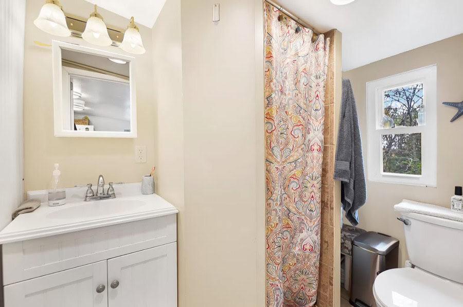 Charming log cabin bathroom with a shower, toilet, and natural light. Perfect for relaxing in a rust.