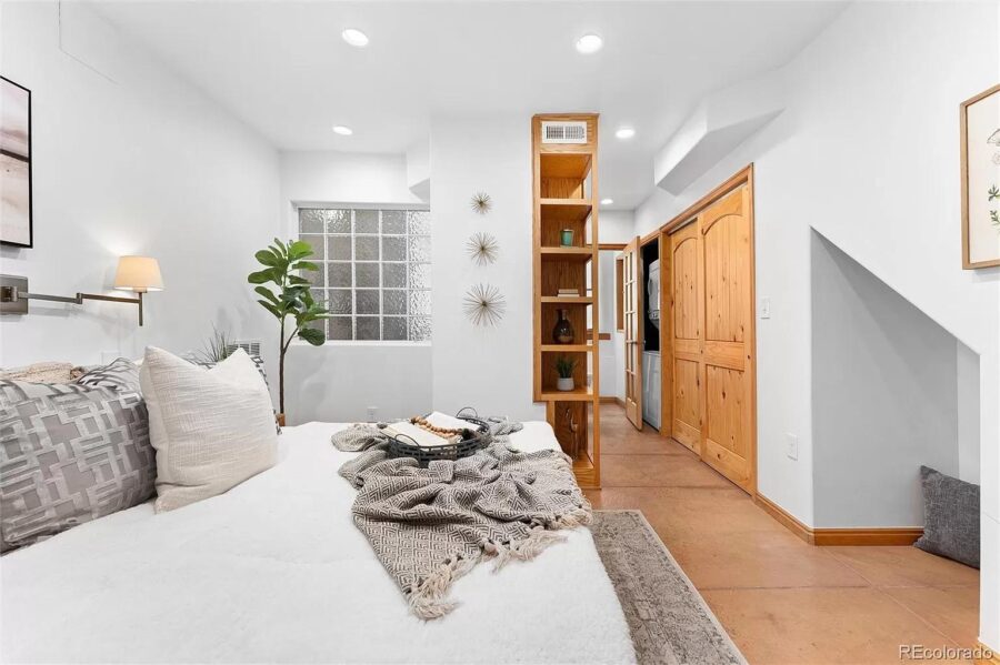 Bright tiny bedroom featuring a cozy bed, wooden storage, and minimalist decor.