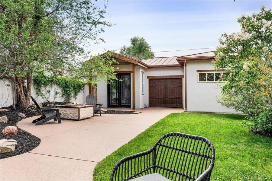 Charming 786 sq. ft. Spanish-style tiny house featuring a detached garage and inviting outdoor patio.