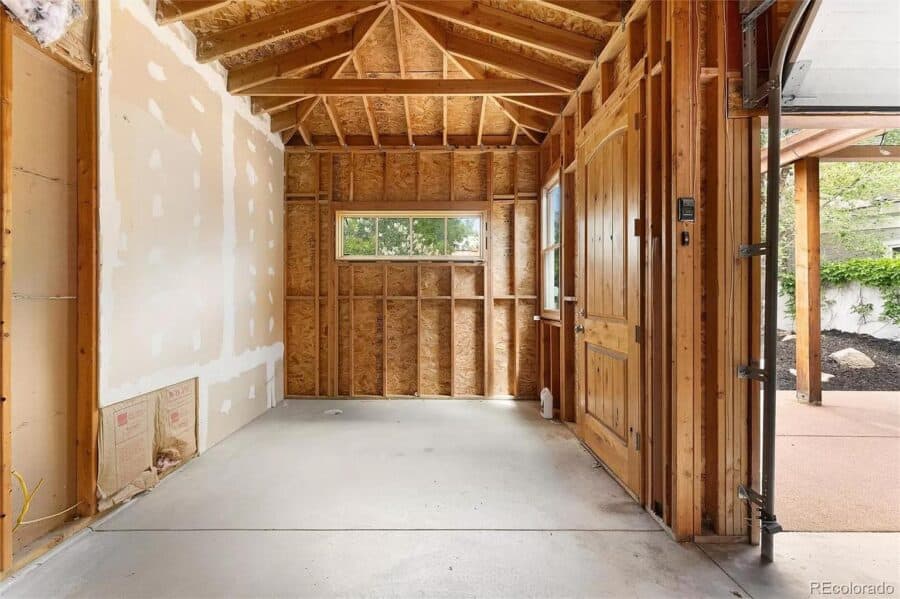Interior framing of a small, modern tiny house under construction with wooden walls and ceiling.